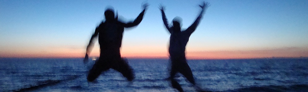 Two guys jumping in front of the baltic sea at sunset